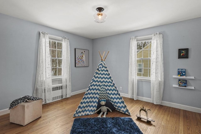 playroom featuring baseboards and hardwood / wood-style flooring