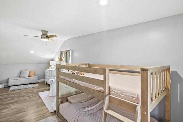 bedroom featuring lofted ceiling, ceiling fan, baseboards, and wood finished floors