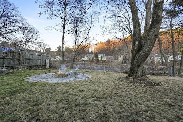 view of yard featuring an outdoor fire pit, a fenced backyard, and a patio