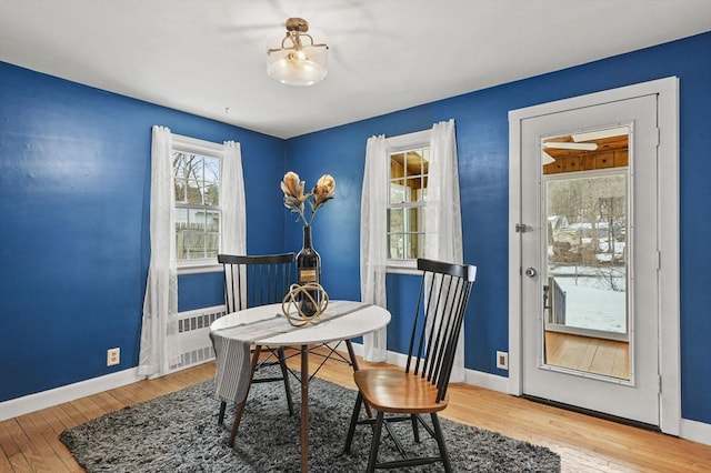 dining area with baseboards and wood finished floors