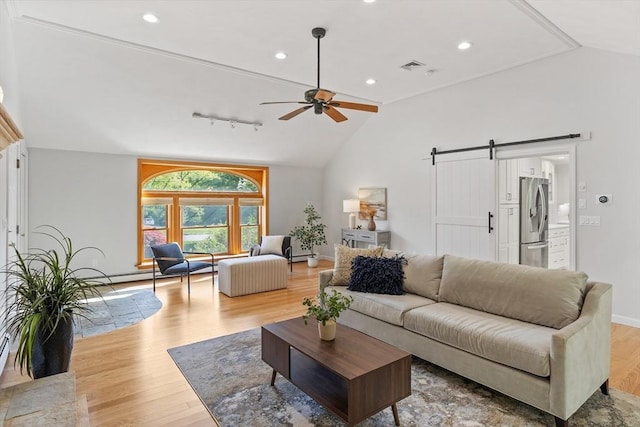 living room featuring lofted ceiling, ceiling fan, wood finished floors, a barn door, and rail lighting