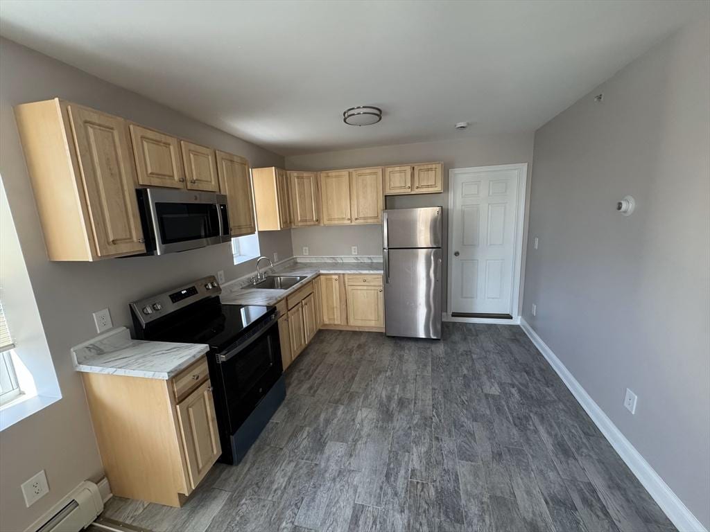 kitchen with sink, a baseboard radiator, dark hardwood / wood-style flooring, light brown cabinetry, and appliances with stainless steel finishes