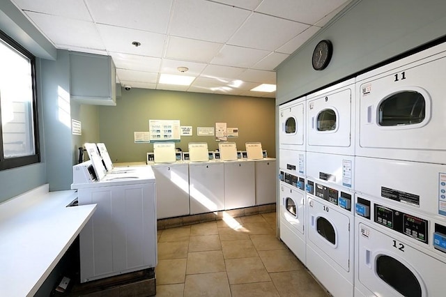 washroom with separate washer and dryer, light tile patterned floors, and stacked washing maching and dryer