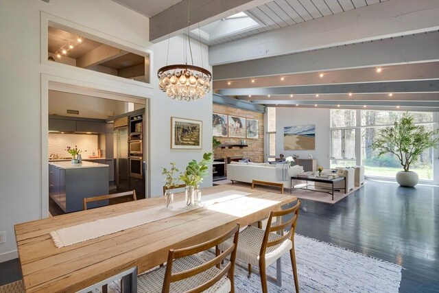 dining space with wood finished floors, beam ceiling, and a notable chandelier