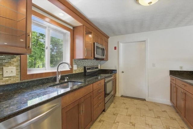 15 Temi Rd, Beverly, MA 01915 - kitchen with appliances with stainless steel finishes, a sink, dark stone countertops, decorative backsplash, and brown cabinetry