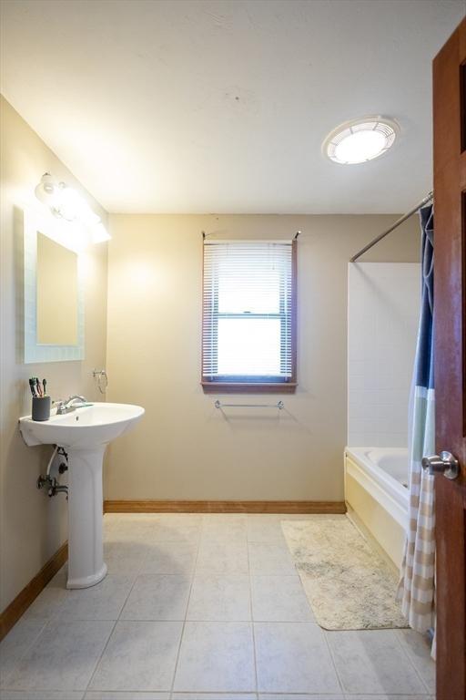 bathroom featuring shower / bathtub combination with curtain and tile patterned flooring