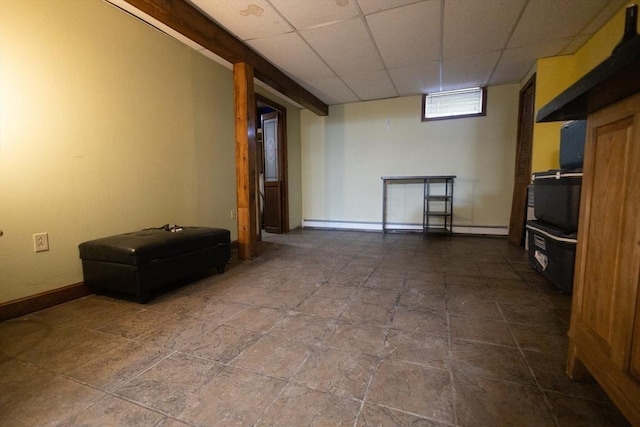 empty room with baseboard heating and a paneled ceiling