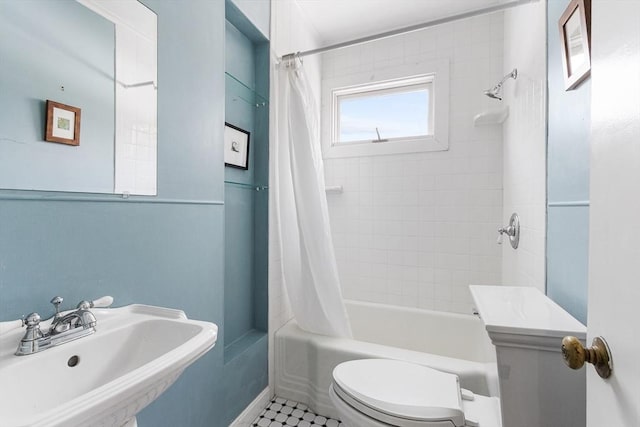 full bathroom with shower / bath combination with curtain, a sink, and toilet