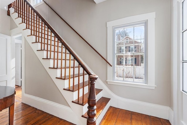 staircase featuring baseboards and wood finished floors