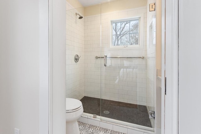 full bath featuring a stall shower, tile patterned flooring, and toilet