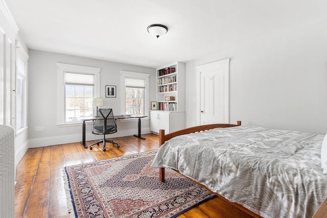 bedroom featuring baseboards and hardwood / wood-style flooring