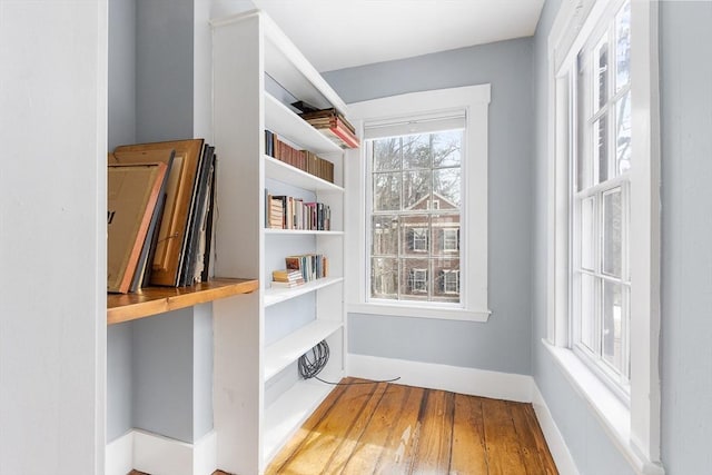 interior space with baseboards, wood finished floors, and built in study area