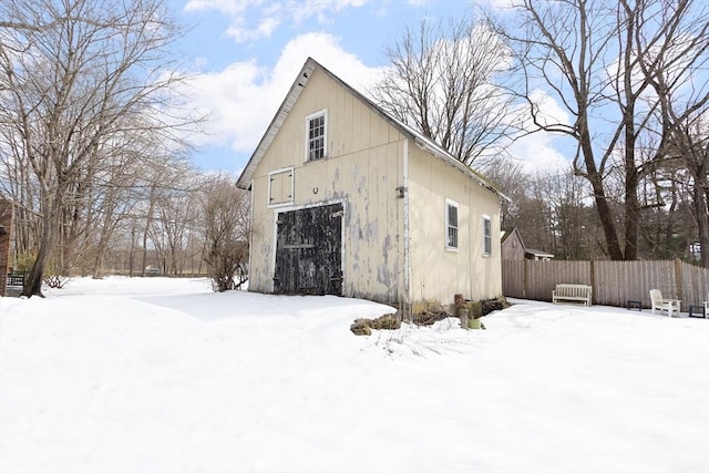 exterior space featuring a garage, fence, and an outbuilding