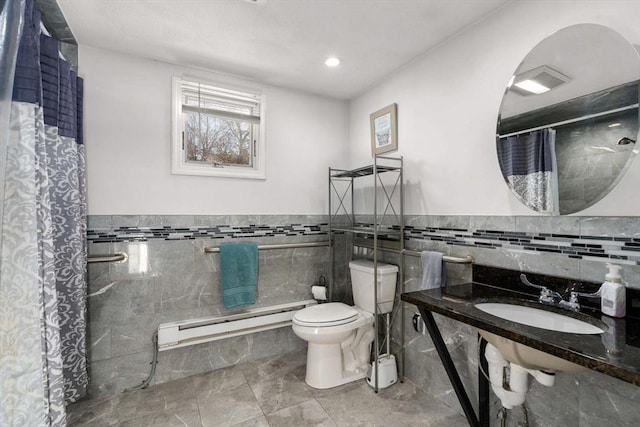 bathroom with toilet, tile walls, baseboard heating, sink, and a shower with shower curtain