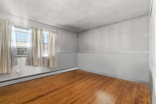 unfurnished room featuring hardwood / wood-style flooring, cooling unit, and a baseboard heating unit