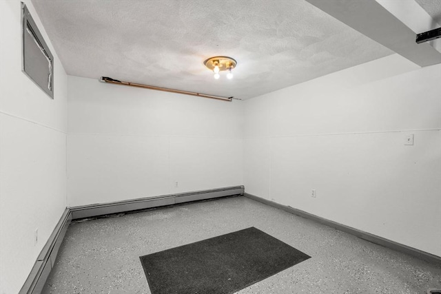 unfurnished room with baseboard heating and a textured ceiling