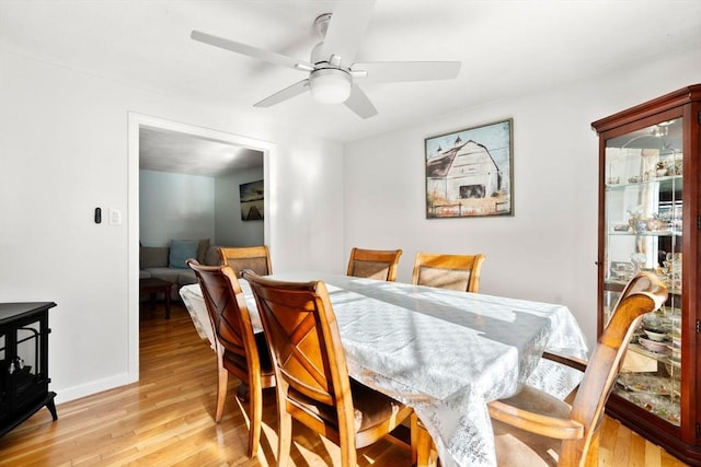 dining space featuring light wood-type flooring and ceiling fan