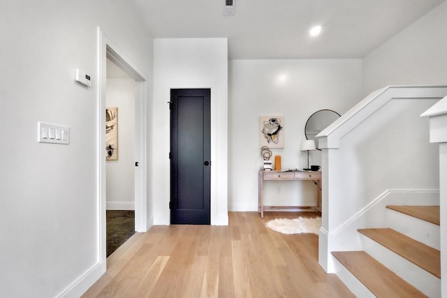 entryway with visible vents, stairs, baseboards, and wood finished floors