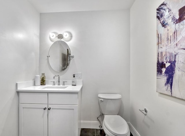 half bath featuring tile patterned flooring, toilet, vanity, and baseboards