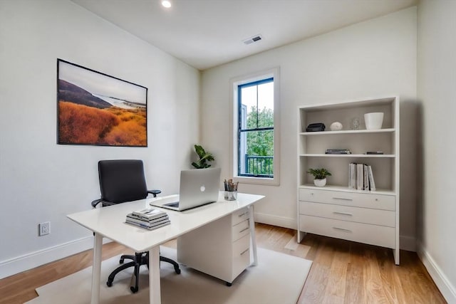 home office with visible vents, baseboards, and light wood-style floors