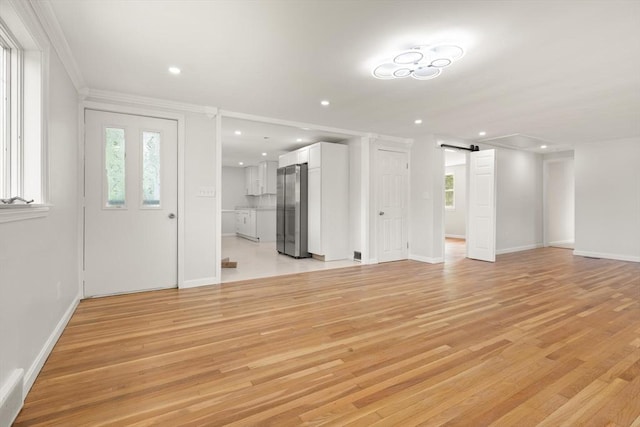 651 S Main St, Randolph, MA 02368 - unfurnished living room with a barn door, light wood-style flooring, plenty of natural light, recessed lighting, and ornamental molding