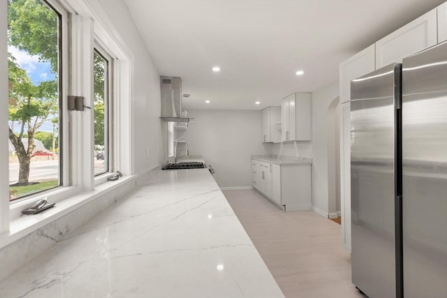 651 S Main St, Randolph, MA 02368 - kitchen with freestanding refrigerator, light stone counters, white cabinets, recessed lighting, and baseboards