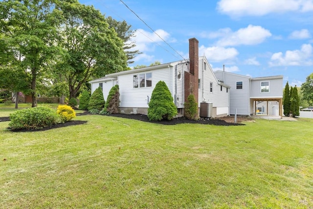 651 S Main St, Randolph, MA 02368 - rear view of property with a yard, a chimney, and central air condition unit