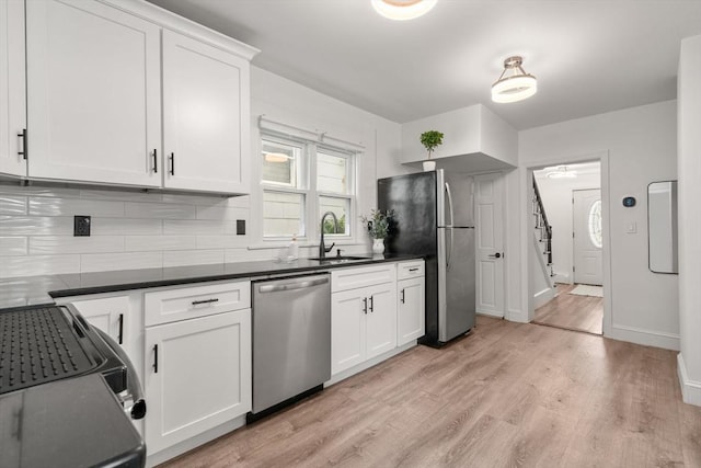 20 Pleasant View Ave, Everett, MA 02149 - kitchen featuring stainless steel appliances, backsplash, light wood-type flooring, dark countertops, and white cabinets