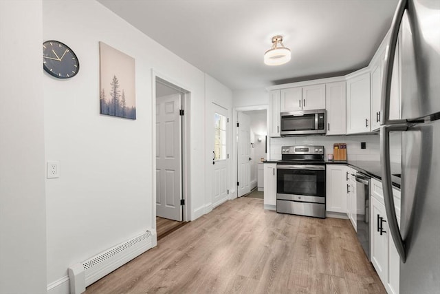 20 Pleasant View Ave, Everett, MA 02149 - kitchen featuring appliances with stainless steel finishes, dark countertops, a baseboard radiator, and white cabinetry