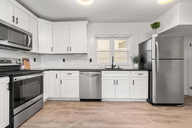 20 Pleasant View Ave, Everett, MA 02149 - kitchen with appliances with stainless steel finishes, white cabinetry, dark countertops, and light wood-style flooring