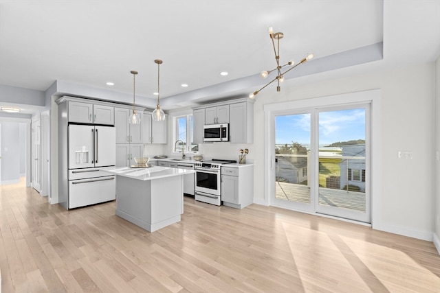 kitchen with white appliances, light hardwood / wood-style floors, a center island, and gray cabinets