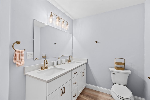 bathroom with wood-type flooring, toilet, and vanity