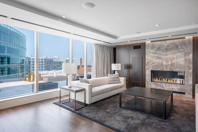 living room featuring wood-type flooring and a high end fireplace