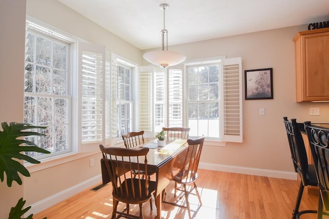 dining room with light wood-type flooring, visible vents, and baseboards