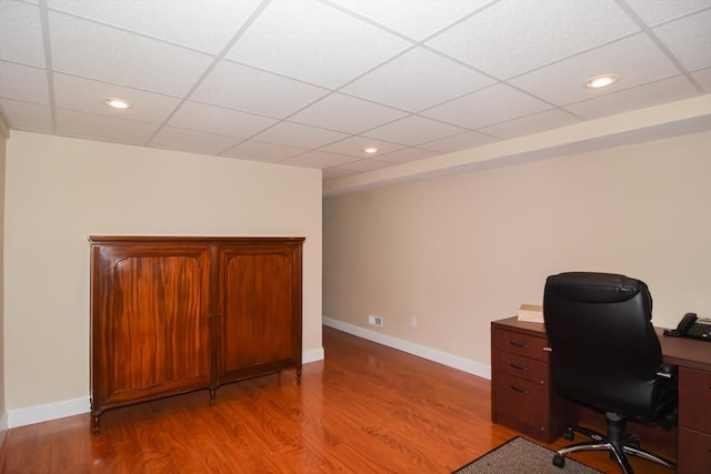 unfurnished office featuring a drop ceiling, recessed lighting, light wood-style flooring, and baseboards