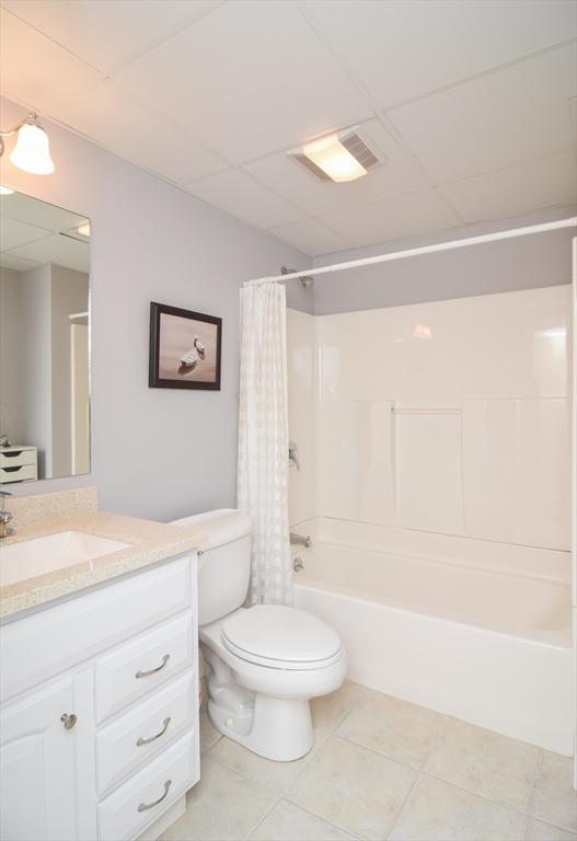 full bath featuring toilet, vanity, visible vents, tile patterned floors, and shower / bathtub combination with curtain