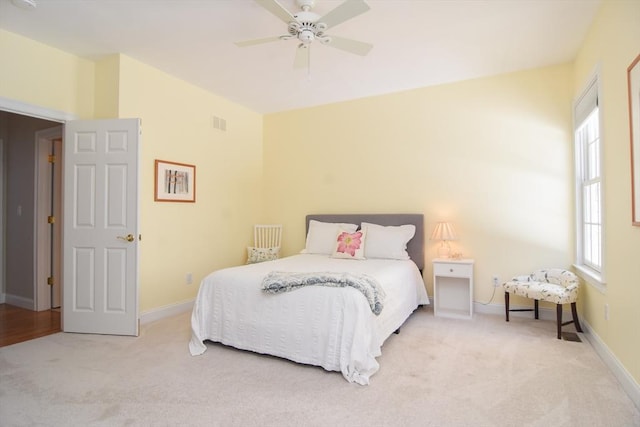 bedroom featuring light carpet, ceiling fan, and baseboards