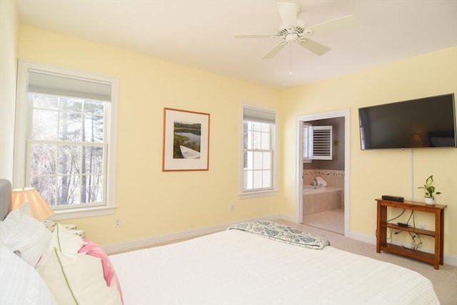 bedroom with baseboards, multiple windows, and ensuite bath