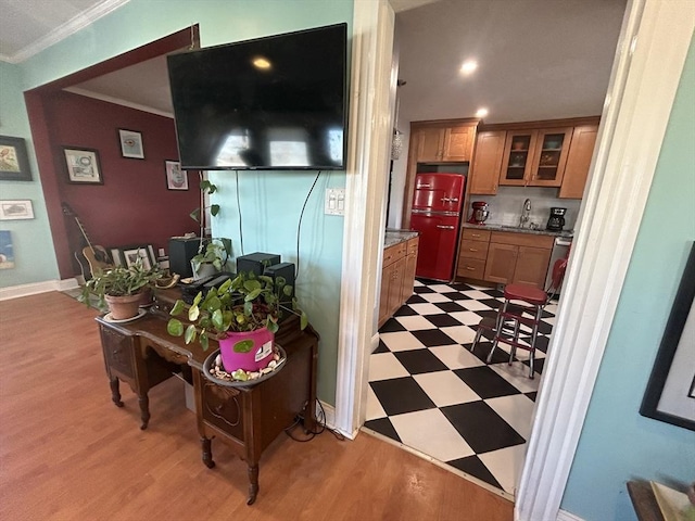 kitchen featuring light stone counters, sink, and ornamental molding