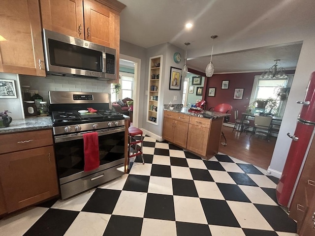 kitchen with a breakfast bar, decorative light fixtures, built in features, stainless steel appliances, and backsplash