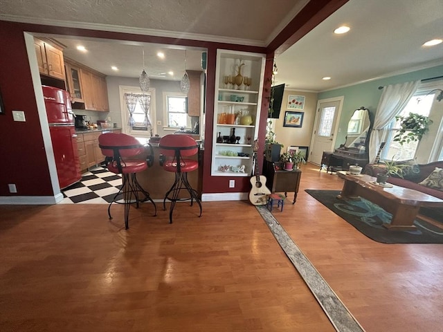 dining room featuring built in shelves, ornamental molding, and hardwood / wood-style floors