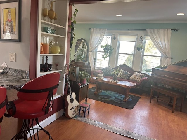 living area featuring hardwood / wood-style flooring and crown molding