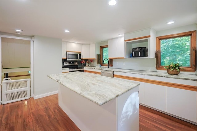 161 N Worcester St, Norton, MA 02766 - kitchen featuring appliances with stainless steel finishes, white cabinetry, wood finished floors, a center island, and recessed lighting