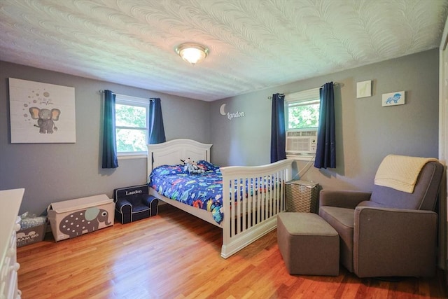 161 N Worcester St, Norton, MA 02766 - bedroom with multiple windows, cooling unit, light wood-style flooring, and a textured ceiling