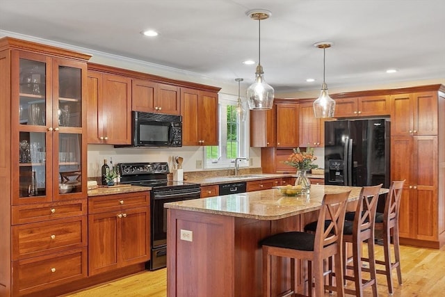 86 S Cross Rd, Haverhill, MA 01835 - kitchen featuring black appliances, a sink, brown cabinetry, a center island, and crown molding