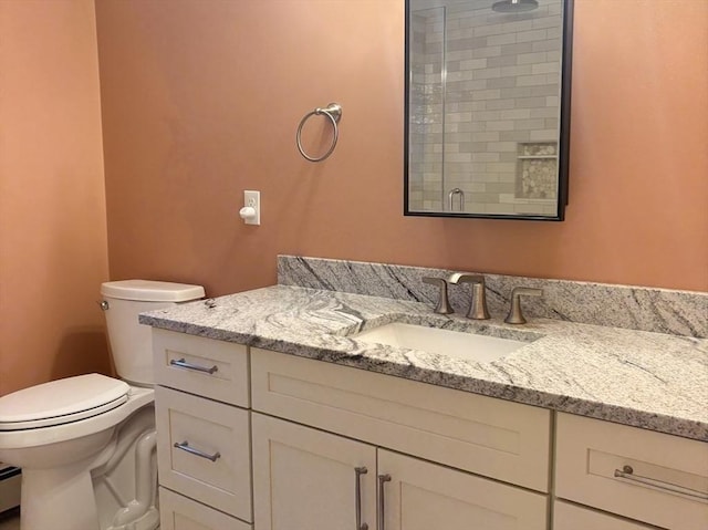 full bath featuring a stall shower, vanity, toilet, and baseboard heating