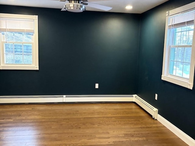 spare room featuring ceiling fan, baseboards, and wood finished floors