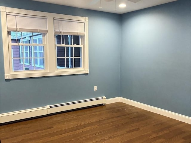 empty room with a ceiling fan, baseboards, baseboard heating, and wood finished floors