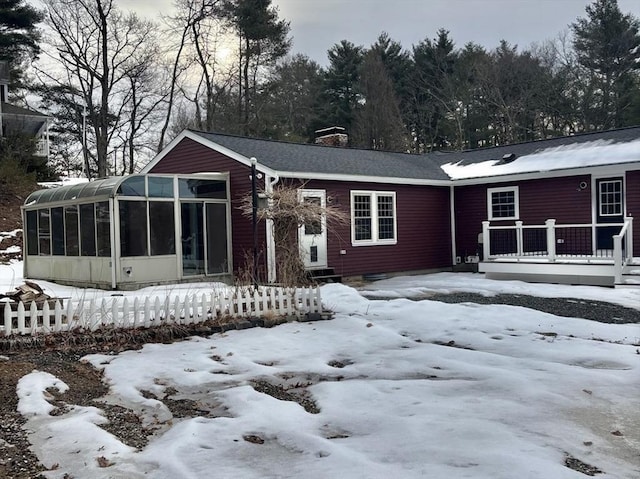 view of front of property with a sunroom and a chimney