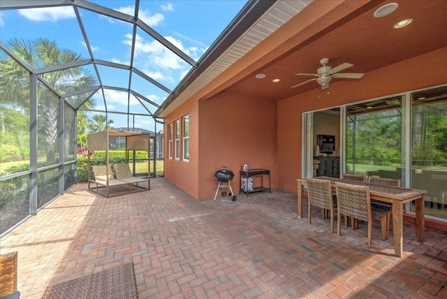 view of patio with ceiling fan and glass enclosure